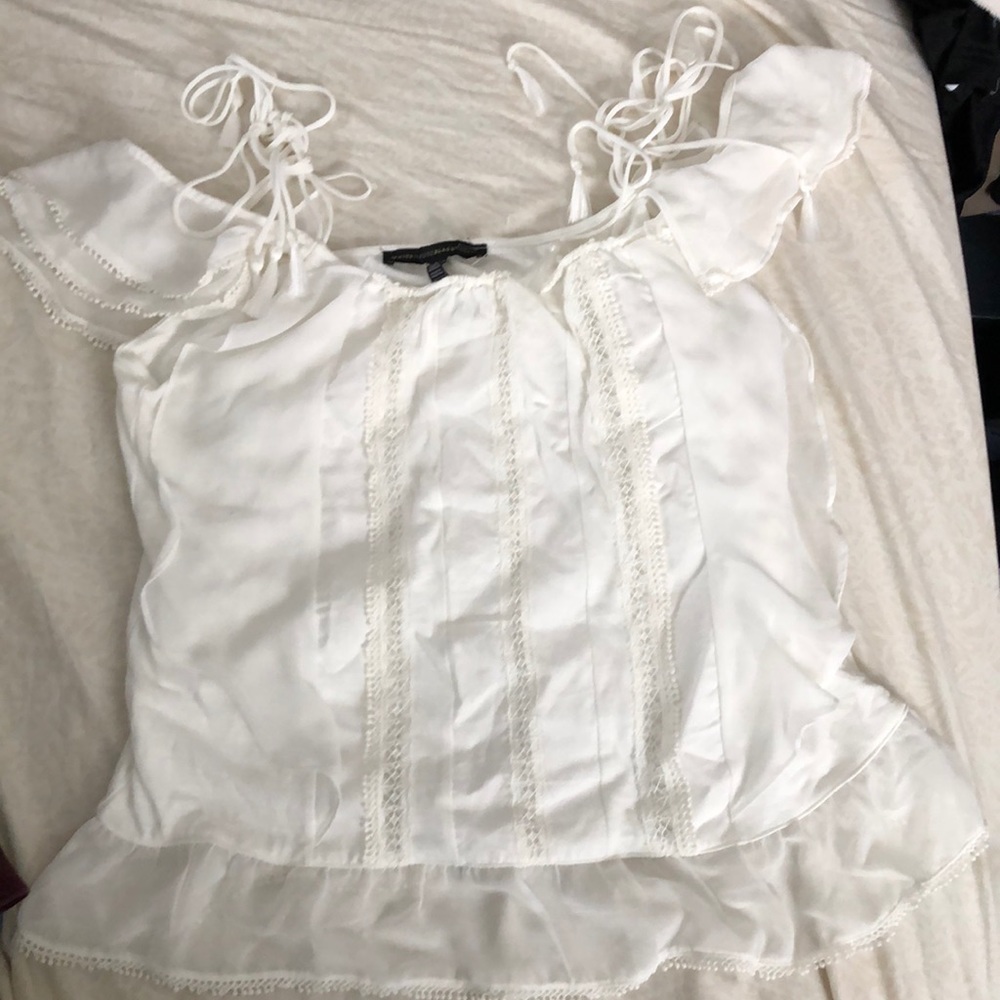 Light cream colored sleeveless blouse.